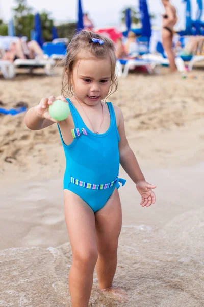 Adorable petite fille debout sur la plage tropicale — Photo