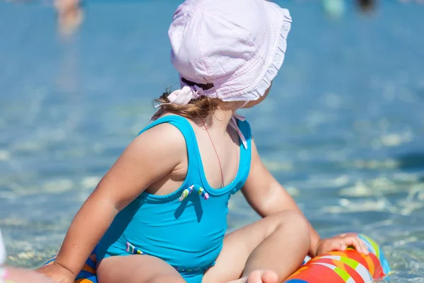 Enfant fille joue sur la plage de sable près de la mer bleue — Photo