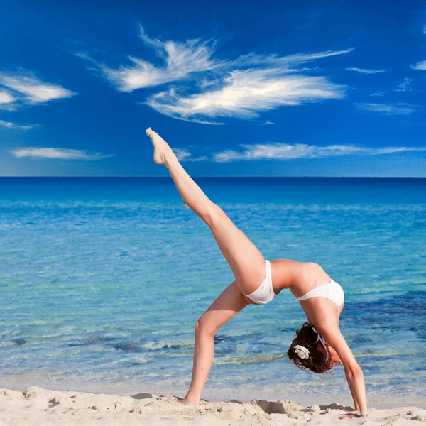 A woman is doing flexibility exercise in the sea — Stock Photo, Image