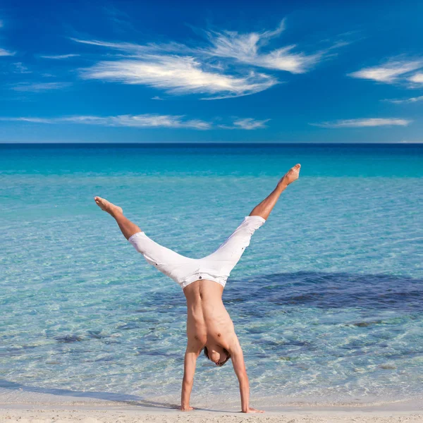 A man is standing upside down on the beach — Stock Photo, Image