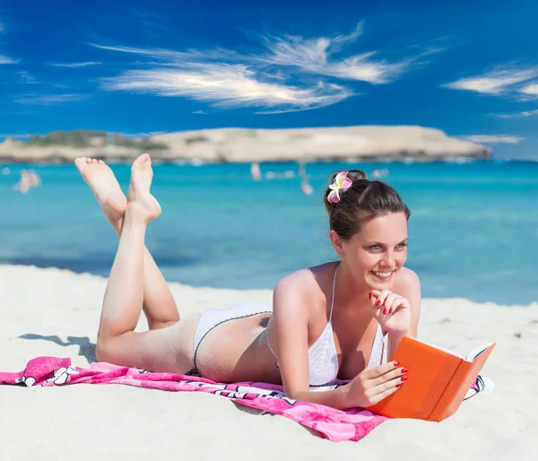 Mulher está lendo um livro em uma praia — Fotografia de Stock