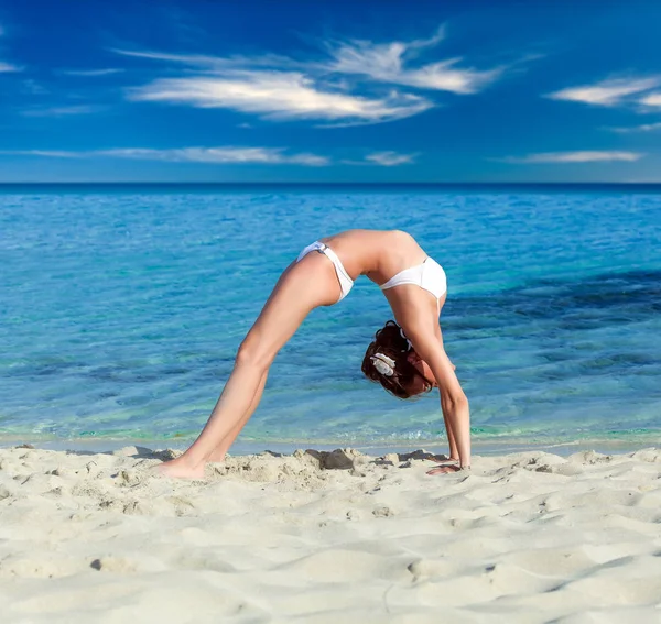 A woman is doing exercises on the beach — Stock Photo, Image