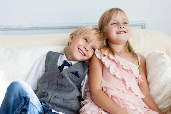 Bror och syster sitter i soffan — Stockfoto