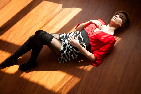 Beautiful woman lying on a floor — Stock Photo, Image