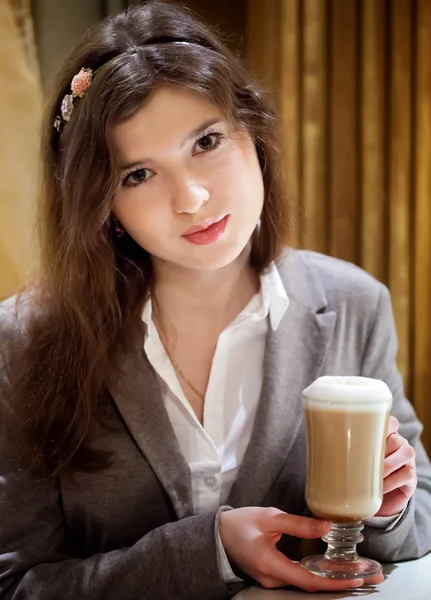 Beautiful brunette woman in restaurant drinking coffee