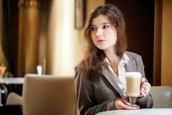 Beautiful brunette woman in restaurant drinking coffee
