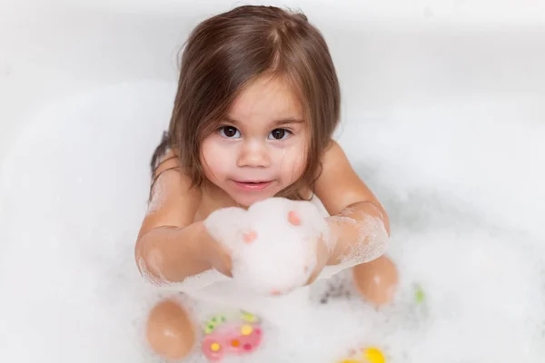Vicces baba lány játszik a víz és a hab — Stock Fotó