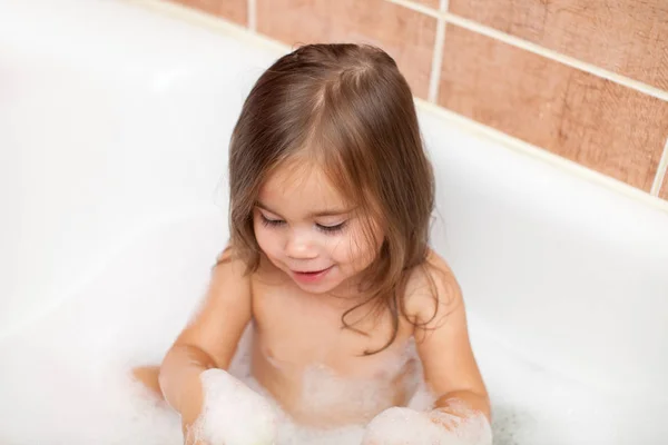 Funny baby girl playing with water and foam — Stock Photo, Image