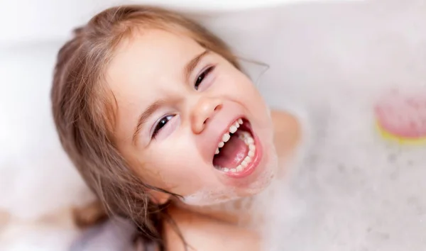 Küçük güzel kız bir köpüklü bir duş alıyor — Stok fotoğraf