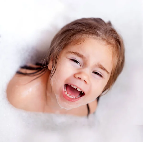The girl playing in bath with foam — Stock Photo, Image