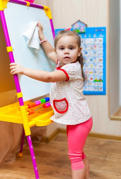 Child girl cleaning the white board — Stock Photo, Image