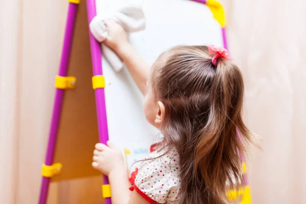 Child girl cleaning the white board — Stock Photo, Image