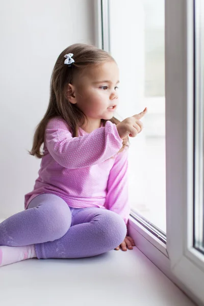 Carina bambina seduta sul davanzale della finestra — Foto Stock