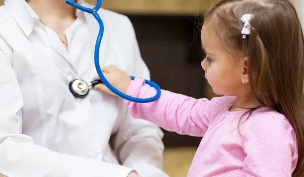 Criança com estetoscópio examinando um médico — Fotografia de Stock