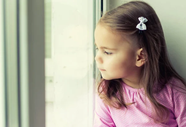 Niña mirando por la ventana — Foto de Stock