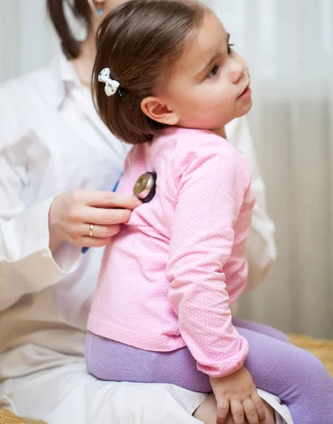 Médico com estetoscópio examinando uma menina criança — Fotografia de Stock