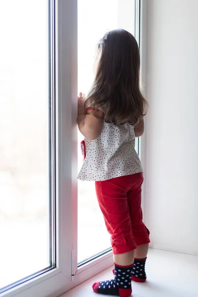 Αναστατωμένος κορίτσι ψάχνει μέσα από το παράθυρο — Φωτογραφία Αρχείου