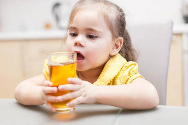 Klein meisje drinken appelsap — Stockfoto