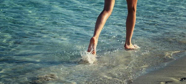 Pernas femininas andando pela praia — Fotografia de Stock