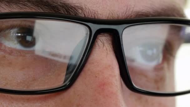 Gros plan de l'homme en lunettes surfant sur Internet. Vidéo UltraHD — Video