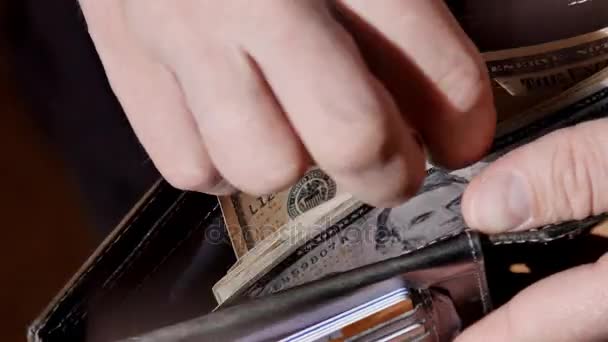 Χέρια επιχειρηματίας μετρώντας τους λογαριασμούς δολαρίων για το πορτοφόλι του. UltraHD βίντεο — Αρχείο Βίντεο