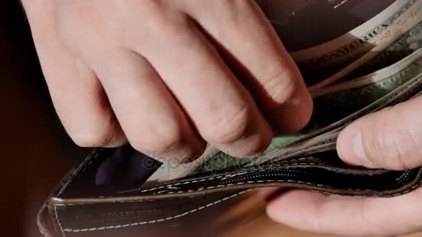 Empresario manos contando billetes de dólar en su cartera. Vídeo UltraHD — Vídeo de stock