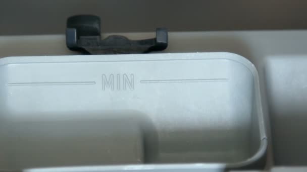 Рука кладет таблетку моющего средства в посудомоечную машину — стоковое видео