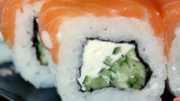 Japansk sushi på svart plåt. 4 k Ultrahd-video — Stockvideo