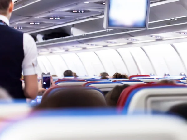 Ряд сидений с мониторами внутри самолета — стоковое фото