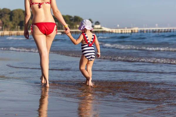 Mor och hennes dotter som promenerar på stranden — Stockfoto