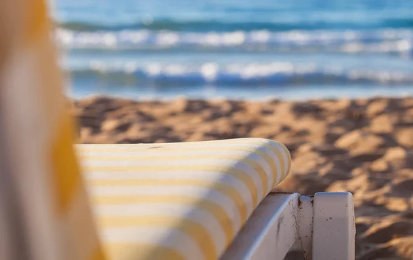 Strandstoel aan zandstrand van blauwe zee — Stockfoto
