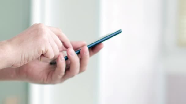 Close-up de homem escrevendo SMS em seu smartphone. Imagens de vídeo UltraHD — Vídeo de Stock