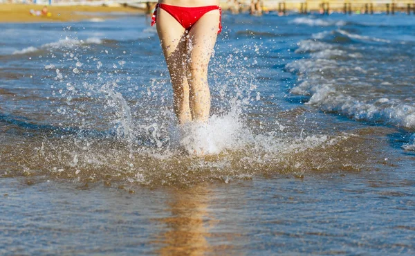 美丽的女性腿在海滩上溅水 — 图库照片