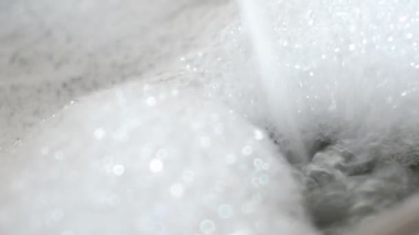 Flow of water into bath with foam. UltraHD video — Stock Video