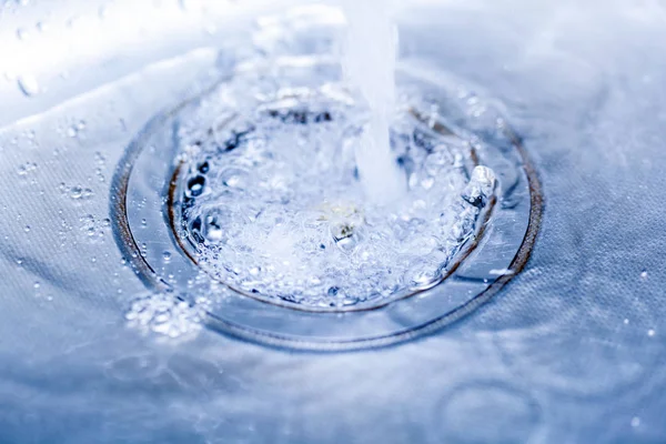 Water in steel sink in blue tones — Stock Photo, Image
