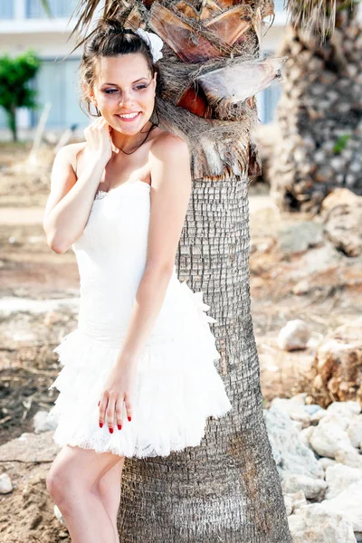 ヤシの木の近くの熱帯のビーチの白いドレスの女. — ストック写真