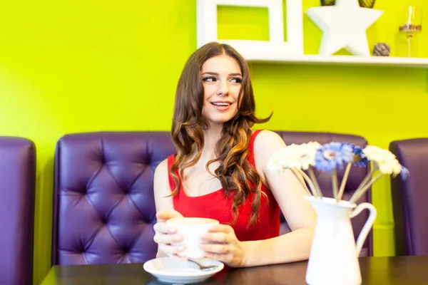 Jonge vrouw die koffie drinkt in een café — Stockfoto