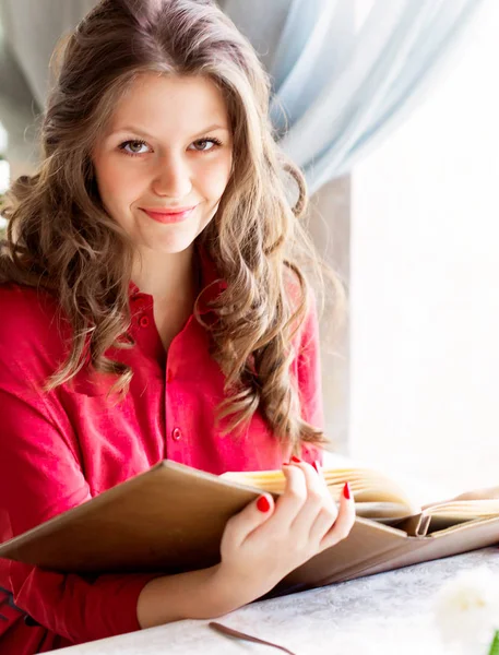 Belle femme regardant le menu et commandant des aliments dans le café Images De Stock Libres De Droits