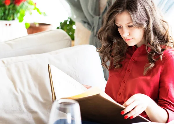 Beautiful woman at the restaurant. The girl is choising food in the menu. — Stock Photo, Image