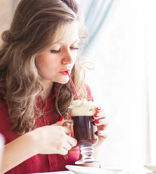 Vacker ung kvinna som dricker kaffe latte på ett kafé — Stockfoto