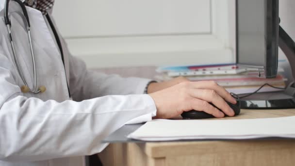 Manlig läkare som arbetar vid sin persondator — Stockvideo