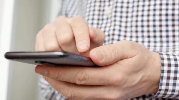 Mãos de homem usando um telefone inteligente, de perto . — Vídeo de Stock