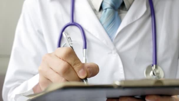 Dokter schrijven geduldige nota's op een medisch onderzoek — Stockvideo