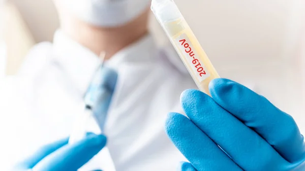 Врач или лаборант, держащий трубку с вакциной против коронавируса NCoV — стоковое фото