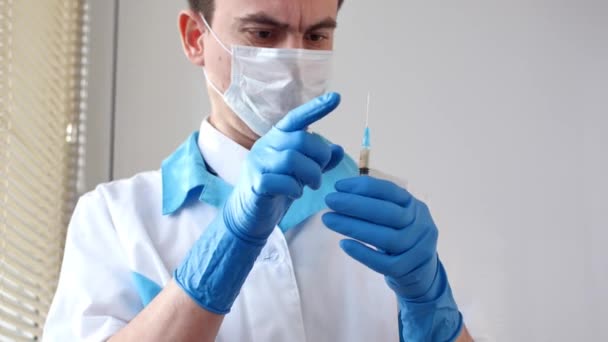 Dokter in medisch masker en blauwe handschoenen bereid voor op injectie. — Stockvideo