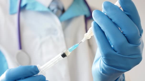 Dokter in medisch masker en blauwe handschoenen bereid voor op injectie. — Stockvideo