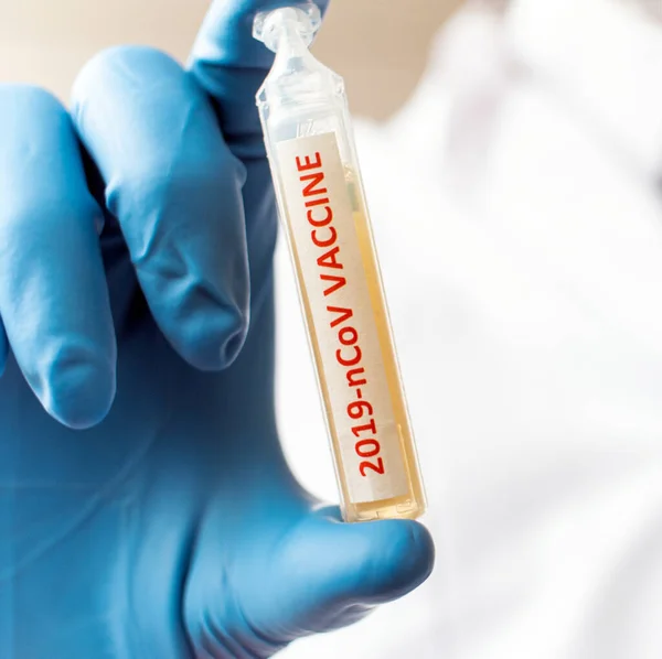 Врач или лаборант, держащий трубку с вакциной против коронавируса NCoV — стоковое фото