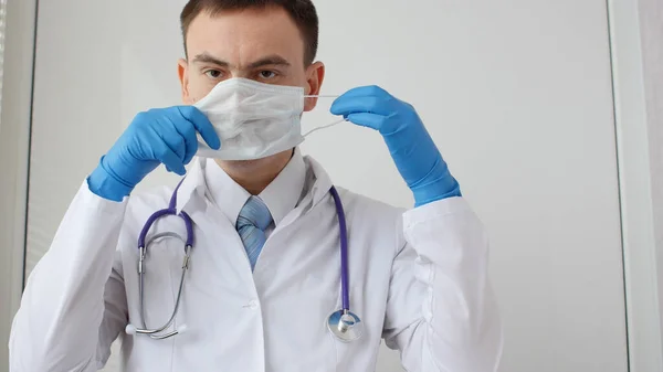 Lékaři ruku s lékařskou obličejovou maskou na ochranu proti infekci — Stock fotografie