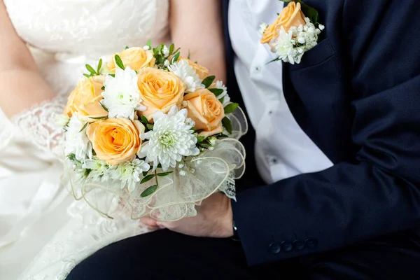 The girl and a guy is sitting togerher and are holding a beautiful bouquet — Stock Photo, Image