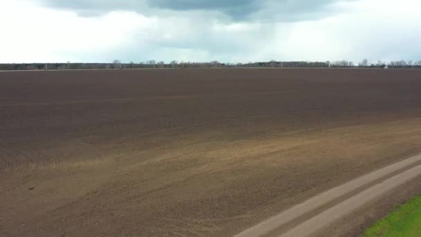 Дорога в поле и бурные облака — стоковое видео